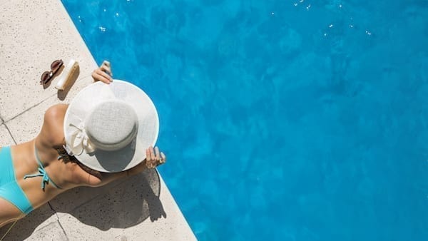 femme été piscine se protège du soleil