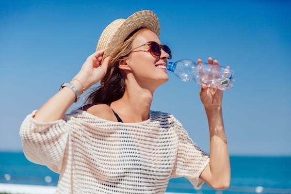 femme qui s'hydrate l'été